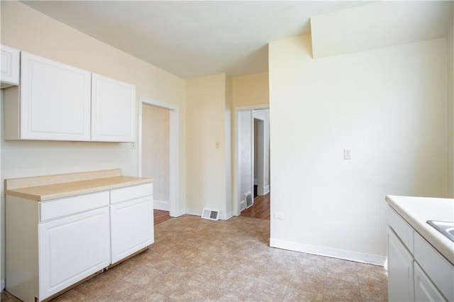 1315 Main St, Aliquippa, PA 15001 - kitchen with light countertops, baseboards, white cabinetry, and visible vents