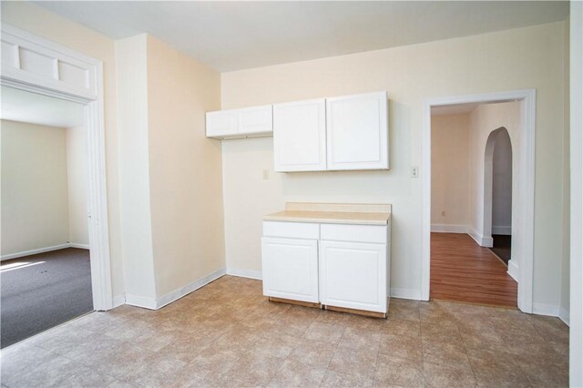 1315 Main St, Aliquippa, PA 15001 - kitchen featuring light countertops, arched walkways, white cabinets, and baseboards
