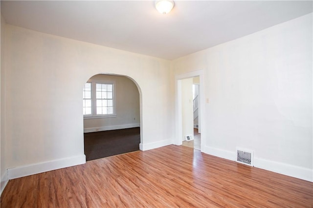 1315 Main St, Aliquippa, PA 15001 - empty room with arched walkways, baseboards, visible vents, and wood finished floors