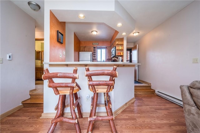 2805 Swiss Mountain Dr, Seven Springs Resort, PA 15622 - kitchen with a peninsula, a breakfast bar, refrigerator, stainless steel microwave, and a baseboard heating unit