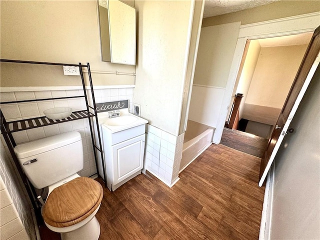 432 Boyles Ave, New Castle/2Nd, PA 16101 - bathroom with a bath, tile walls, wood finished floors, vanity, and toilet