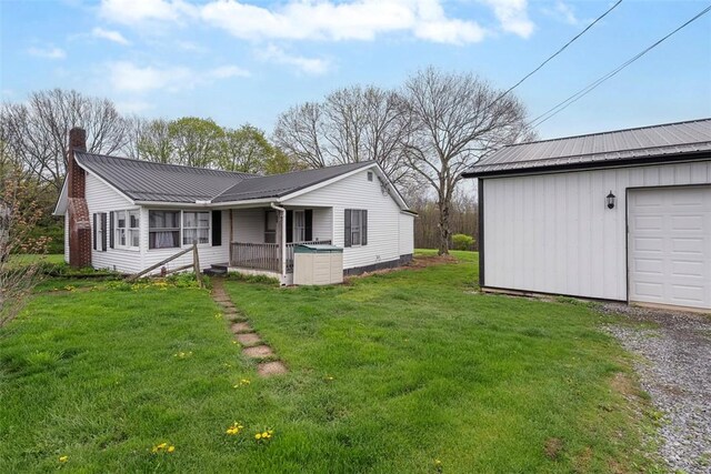 114 Angel Ave, Fairview Twp But, PA 16050 - view of front of home with a chimney, metal roof, a front lawn, gravel driveway, and a garage