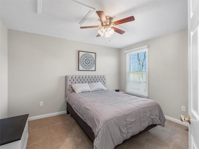 bedroom with baseboards, attic access, ceiling fan, and light carpet