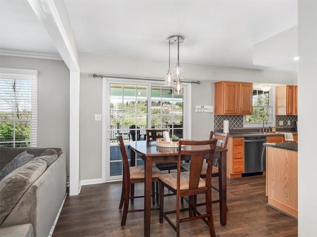 dining room featuring baseboards, ornamental molding, and dark wood-style flooring