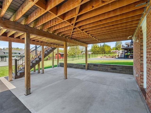 view of patio featuring stairs and fence