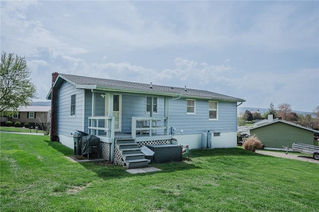 back of property featuring a yard, a deck, and a chimney