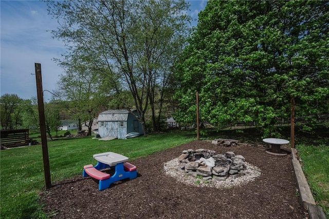 view of yard featuring an outdoor structure, a fire pit, and a shed