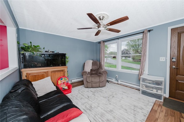 living area featuring wood finished floors, crown molding, ceiling fan, and a baseboard heating unit