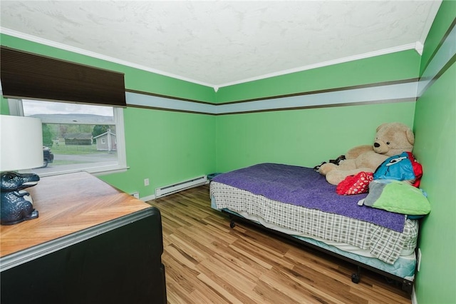bedroom with crown molding, a baseboard radiator, and wood finished floors
