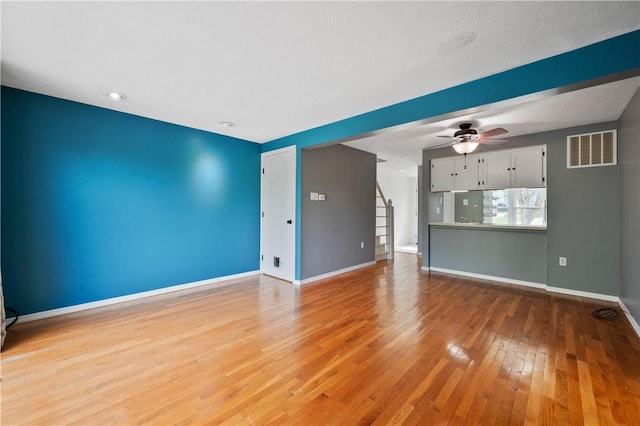 6326 Springhouse Pl, South Fayette, PA 15017 - unfurnished living room featuring a ceiling fan, visible vents, stairway, baseboards, and light wood-style floors