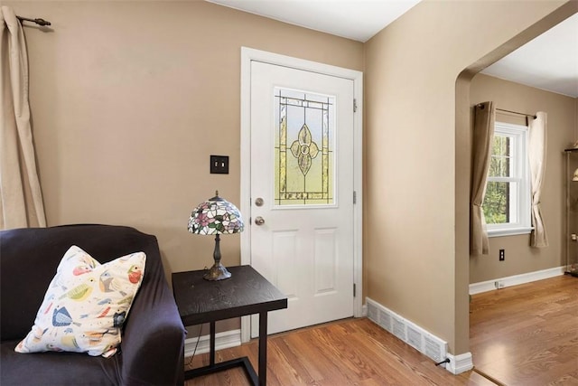 foyer entrance with visible vents, light wood-style flooring, and baseboards