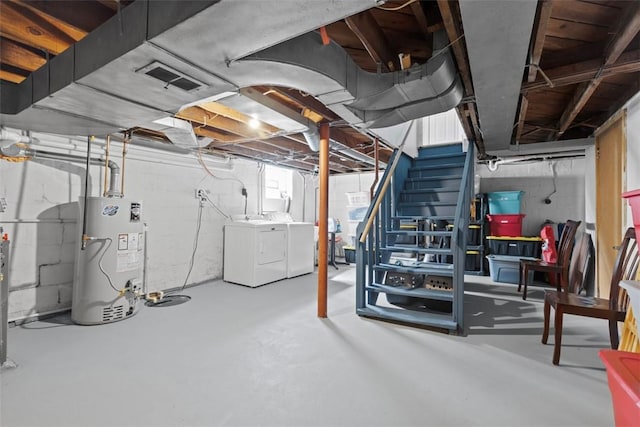 unfinished below grade area featuring water heater, stairs, independent washer and dryer, and visible vents