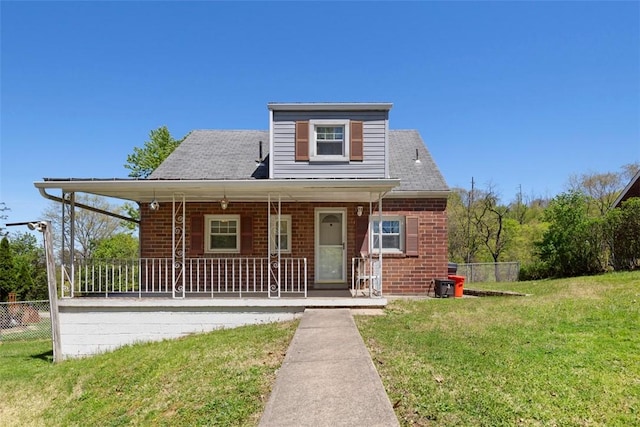 bungalow-style home with a porch, roof with shingles, brick siding, fence, and a front lawn