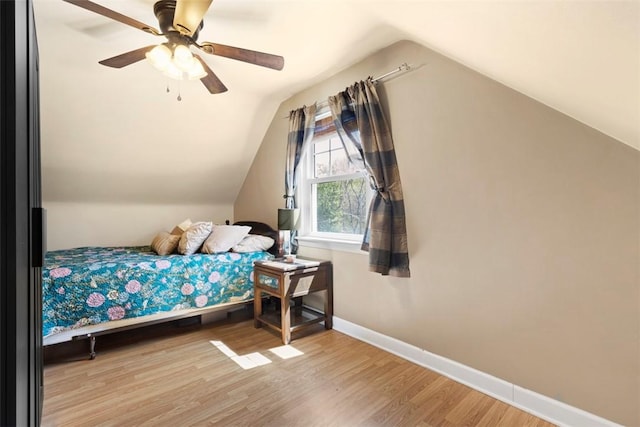 bedroom featuring baseboards, ceiling fan, wood finished floors, and lofted ceiling