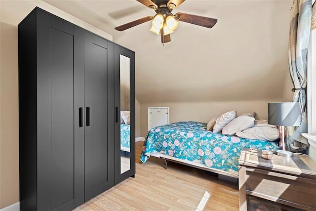 bedroom with a ceiling fan, baseboards, and light wood-style flooring