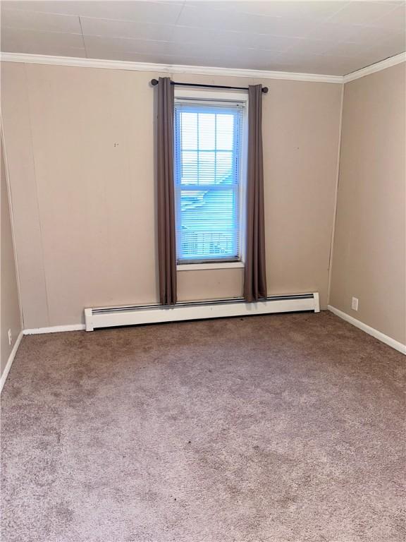 empty room with crown molding, carpet flooring, baseboards, and a baseboard radiator