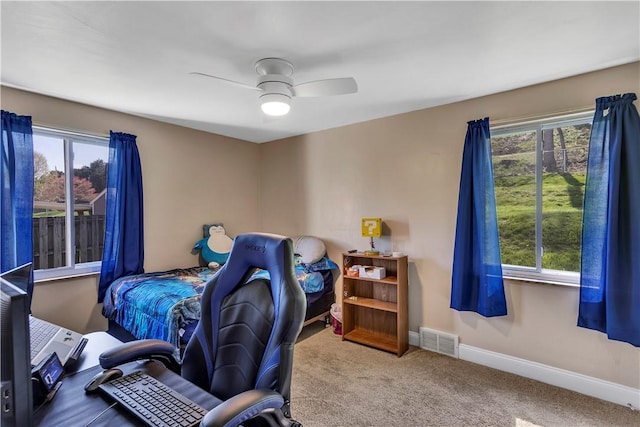 carpeted bedroom featuring visible vents, a ceiling fan, and baseboards