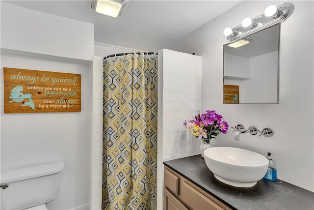bathroom with toilet, curtained shower, and vanity
