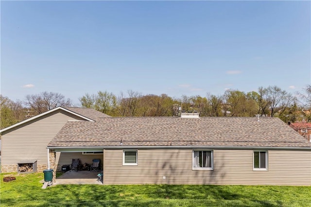 back of property with a lawn, a chimney, and a patio area