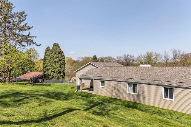 back of property featuring a lawn, fence, and a chimney