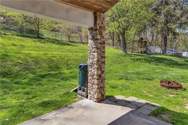 view of yard featuring a fenced backyard, a playground, and an outdoor fire pit