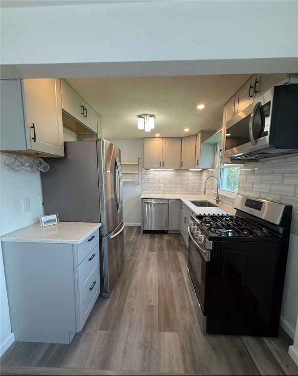 4402 Gateway Dr, Monroeville, PA 15146 - kitchen with decorative backsplash, wood finished floors, light countertops, a sink, and stainless steel appliances