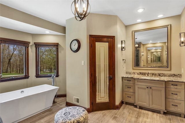 118 Lakeland Dr, Adams Twp, PA 16046 - full bathroom with vanity, baseboards, wood finished floors, visible vents, and a soaking tub
