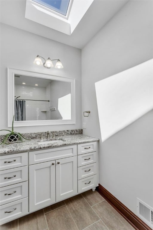 118 Lakeland Dr, Adams Twp, PA 16046 - bathroom featuring visible vents, vanity, a shower, wood tiled floor, and a skylight