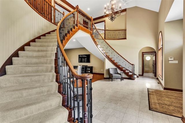 118 Lakeland Dr, Adams Twp, PA 16046 - stairs featuring an inviting chandelier, arched walkways, baseboards, and a towering ceiling