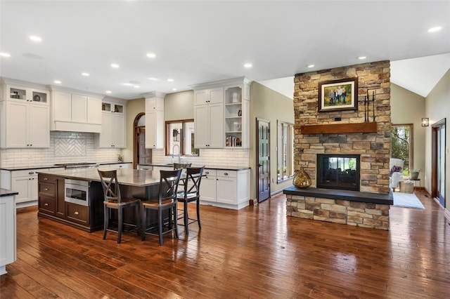 118 Lakeland Dr, Adams Twp, PA 16046 - kitchen featuring a kitchen breakfast bar, a stone fireplace, tasteful backsplash, glass insert cabinets, and stainless steel appliances