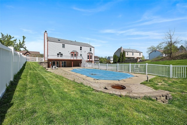 view of swimming pool with a yard, a patio, a fenced in pool, and a fenced backyard