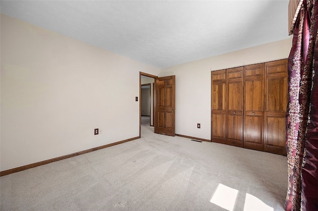 unfurnished bedroom with baseboards, visible vents, and light carpet