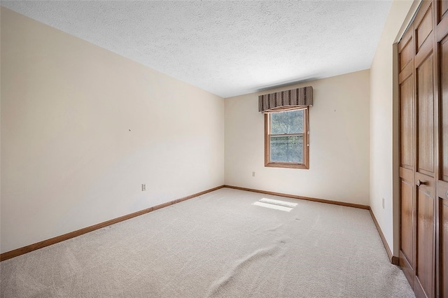 unfurnished bedroom featuring baseboards and light carpet