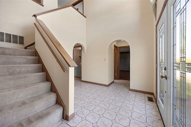 entryway with visible vents, arched walkways, and a wealth of natural light
