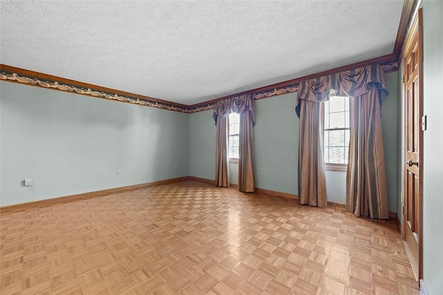 empty room with baseboards, a textured ceiling, and a wealth of natural light
