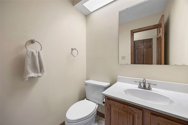 half bathroom with toilet, baseboards, and vanity