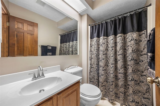 bathroom with vanity, toilet, a textured ceiling, a shower with curtain, and visible vents