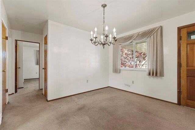 unfurnished dining area featuring baseboards, a chandelier, and light carpet