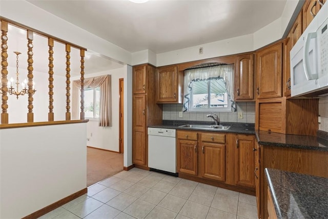 kitchen featuring white appliances, decorative backsplash, brown cabinetry, and a sink