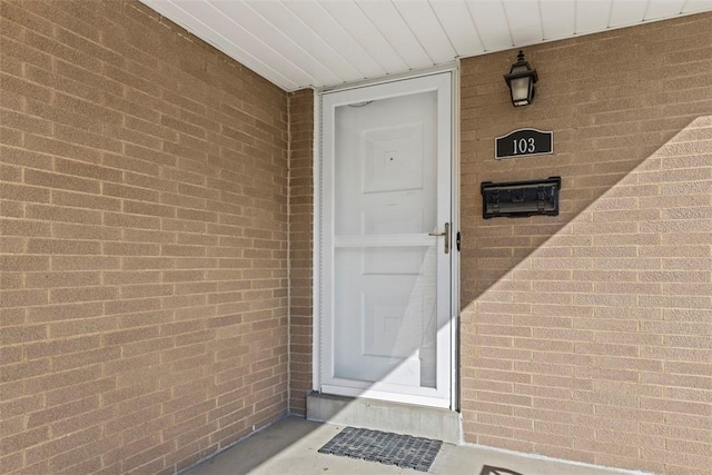 view of exterior entry with brick siding