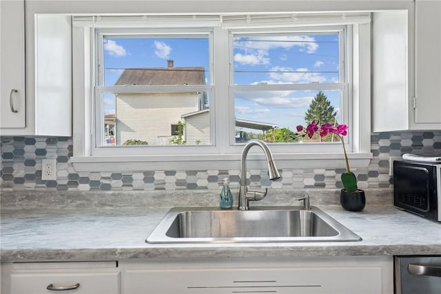 kitchen featuring a sink, light countertops, and white cabinetry