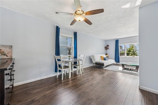 sitting room with a ceiling fan, baseboards, and wood finished floors