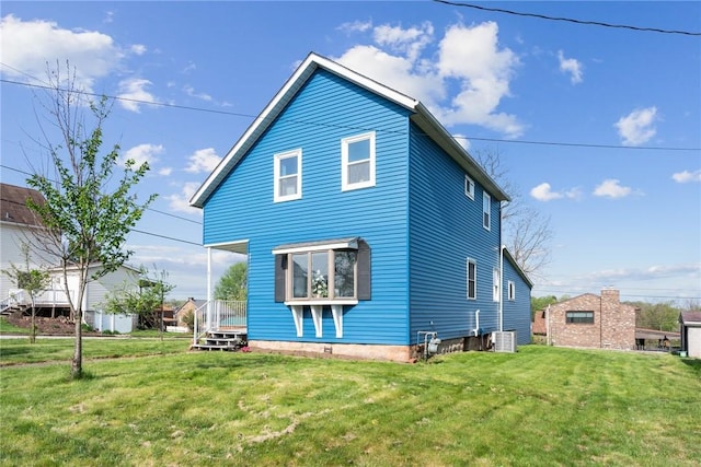 back of house with a lawn and central AC