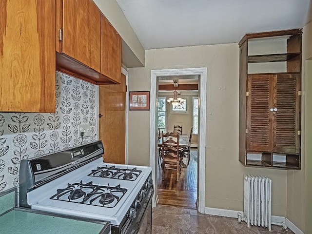kitchen with an inviting chandelier, baseboards, white range with gas cooktop, and radiator heating unit
