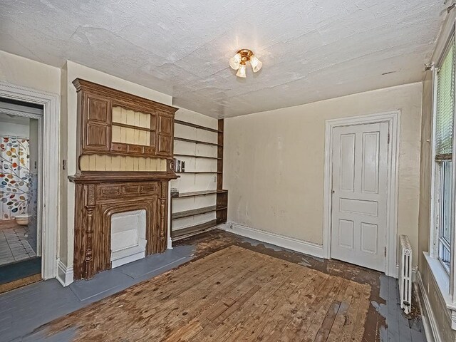 unfurnished living room with baseboards and dark wood-style floors
