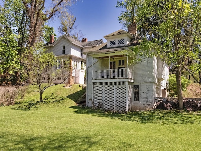 back of house with a lawn and a chimney