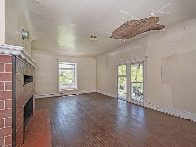 unfurnished living room featuring baseboards, a baseboard radiator, a fireplace, and dark wood-style floors