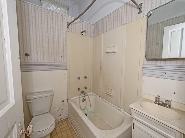 bathroom with vanity, tub / shower combination, toilet, and wallpapered walls