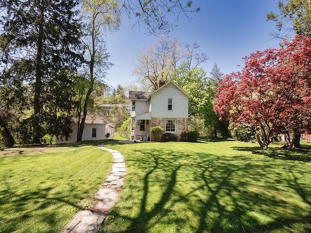 back of property with a yard and a chimney