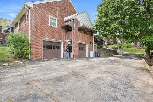 814 Clara St N, Versailles, PA 15137 - view of side of home featuring an attached garage, driveway, and brick siding